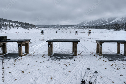 A winter shooting range with empty firing positions and distant targets.