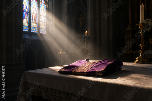 A single sunbeam illuminates a folded chasuble on a stone altar inside a cathedral.