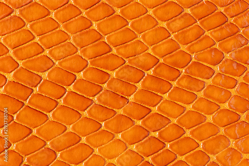 Orange snakeskin leather texture background with geometric reptile scale pattern