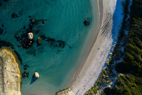 Aerial view of William Bay featuring turquoise water, large granite boulders, white sand beach, and coastal vegetation in William Bay, Western Australia, Australia.
