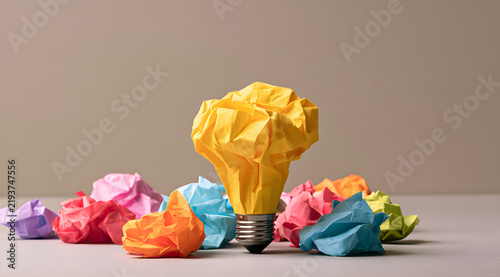 The concept of fail-fast prototyping is represented by a yellow paper lightbulb amidst colorful crumpled paper.