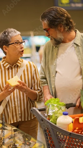 Senior couple buying cheese in the supermarket