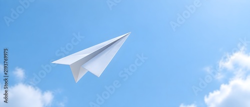 Paper airplane angled upward against a seamless pale sky background conveying ambition and positive inclination