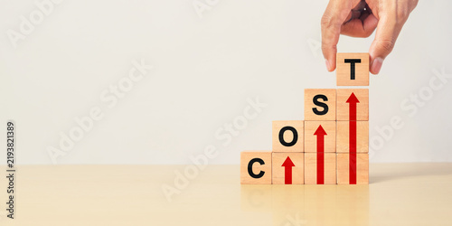Cost increase and inflation concept. The word cost on wooden cubes with arrows going up.