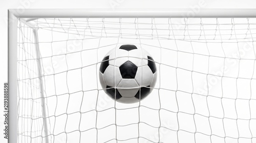 Classic black and white soccer ball hitting the goal net isolated on a pure white background