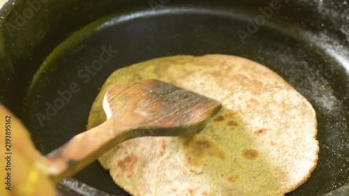 Woman Preparing Fresh Multigrain Roti on a Traditional Cast Iron Tawa