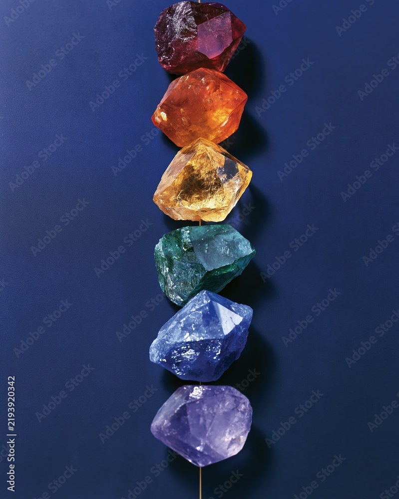Obraz premium vertical rainbow colored gemstones on blue background