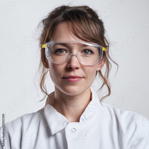 Portrait of female scientist wearing safety glasses studio lighting 100% white background