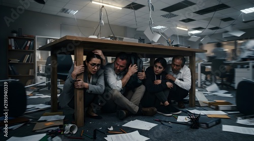 People Hiding Under Office Table During Earthquake. Earthquake Safety and Emergency Preparedness Concept