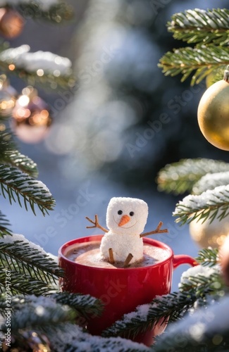 Cute Snowman Marshmallow in Red Cup with Hot Chocolate Surrounded by Christmas Tree Decor