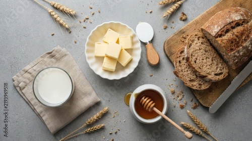 Breakfast table setting with bread, butter, milk and honey