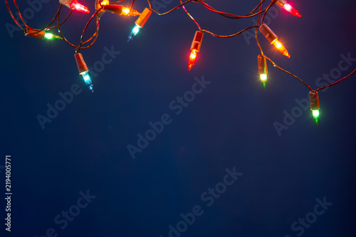 Christmas lights string on blue background with copy space