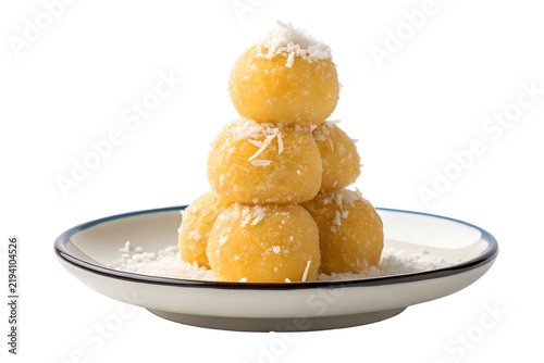Stack of yellow coconut balls on a small ceramic plate isolated on transparent background