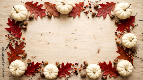 Pumpkins and autumn leaves border on rustic wood. seasonal harvest decoration with acorns