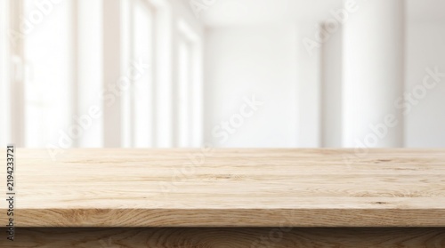 Empty light wooden tabletop for product display with blurred white interior room background.