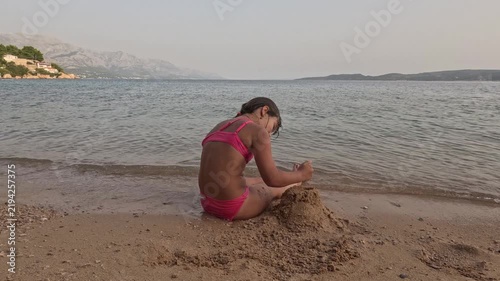 Girl Building Sand Mound on Quiet Croatian Seashore