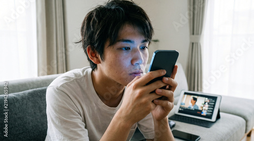 Naklejka スマートフォンに夢中になる若い男性、ドーパミン中毒とデジタル依存のイメージ