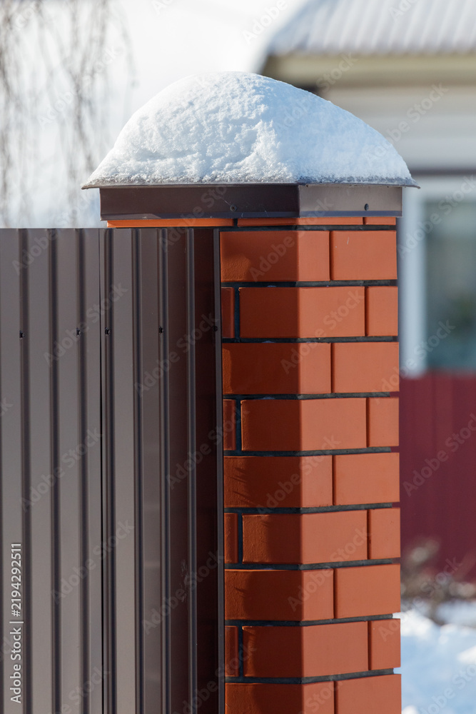 Obraz premium Snow rests atop a brick chimney
