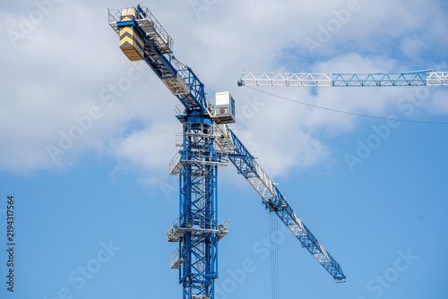 Foto Tower Cranes Against Bright Blue Sky in Construction Site