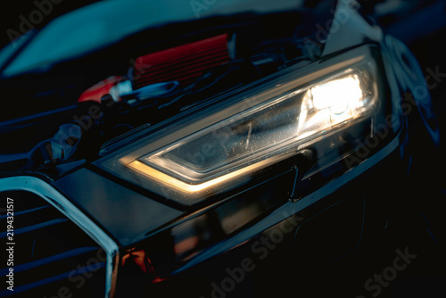 Tuning car engine with glowing headlight at night