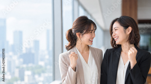 Plakat 向き合ってガッツポーズをして喜ぶ笑顔の会社員の女性2人