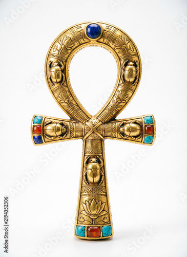 golden ankh with patterns and semi-precious stones on white background
