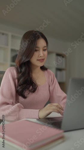 Young asian woman working on laptop from home office