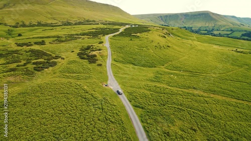 Aerial view of a scenic mountain valley with a winding road through the rugged landscape of Brecon Beacons National Park in Wales, United Kingdom Powys, Wales - 28 August 2026.
