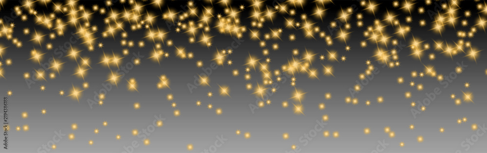 Obraz premium Glowing golden star sparkles scattered over a dark to gray gradient background, creating a festive luxury light effect for holiday designs
