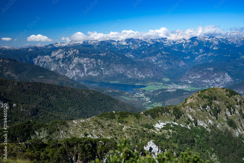 Obraz premium Panoramic view of the Julian Alps and Lake Bohinj from the summit of Črna Prst Mountain in Slovenia