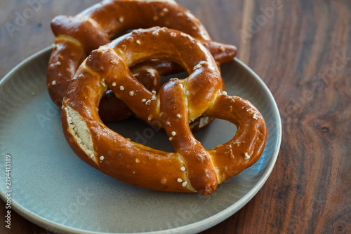 Freshly Baked Salted Soft Pretzels - bavarian lye brown pastry - on Wooden Board