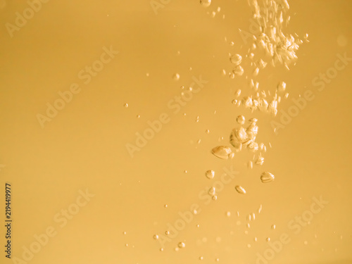 Golden Bubbles Rising in Water, Luxury Cosmetic Texture Background