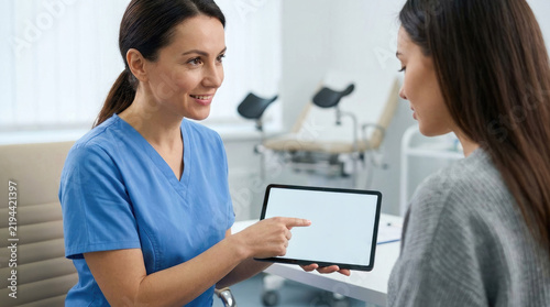 Healthcare professional explaining menstrual health and feminine hygiene to a patient using a tablet in a modern medical clinic.