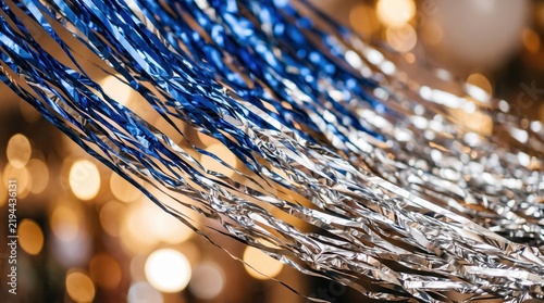 Shiny blue and silver tinsel hanging for a new year party celebration. Festive metallic streamers create a joyful atmosphere indoors.