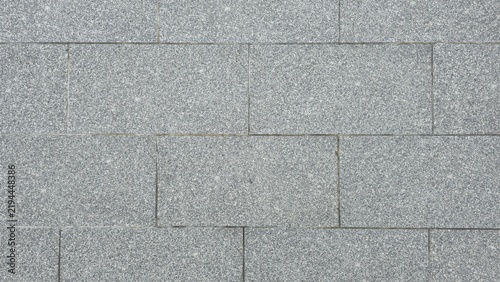 Abstract grey granite paving stone floor texture surface. Grey granite stone blocks floor texture background. Top view pattern of rectangular grey granite tiles on outdoor sidewalk pavement.