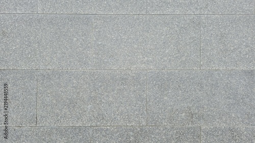 Abstract grey granite paving stone floor texture surface. Grey granite stone blocks floor texture background. Top view pattern of rectangular grey granite tiles on outdoor sidewalk pavement.