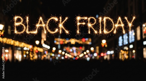 Panoramic sparkler lettering Black Friday against dark blurred city street bokeh background, ideal template for holiday sales promo banner, retail commercial advertisement, seasonal deal marketing.