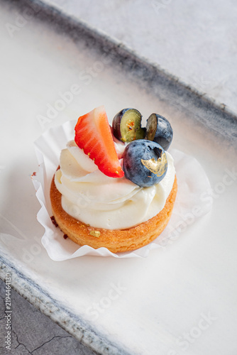 Quadro su tela Delightful dessert with fresh strawberries and blueberries atop creamy icing in