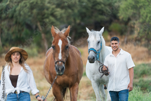 Fotografie Couple walking horses enjoying equestrian lifestyle outdoors