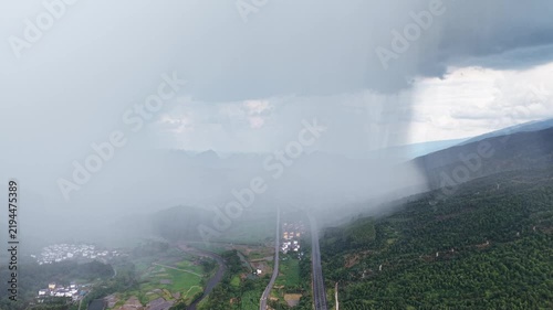 Landscape view: Highway passing through dense rain curtain and fog in a karst mountain area