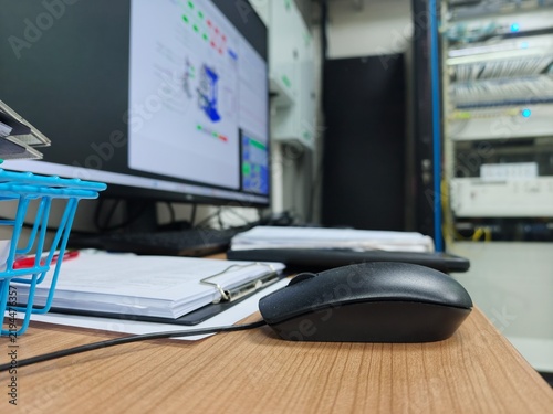 Fotografie A low-angle desktop view in an engineering or server control room, showing a bla