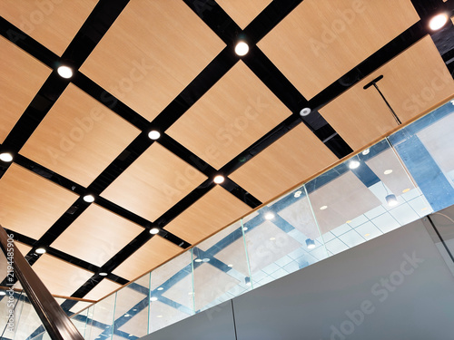 Modern architectural ceiling with wooden panels and glass balustrade in Rzeszow, Poland, contemporary interior design, ambient lighting and geometric pattern