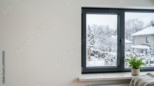 Winter view through a home window with condensation on the glass. Cozy indoor setting with a blanket and radiator next to copy space. Home heating and insulation concept