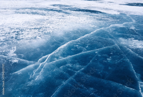 Frozen ice surface with intricate crack patterns under natural light