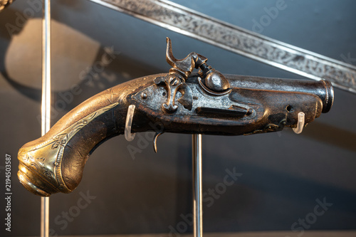 Cuadro en lienzo Close up of an antique flintlock pistol with brass fittings displayed on a stand