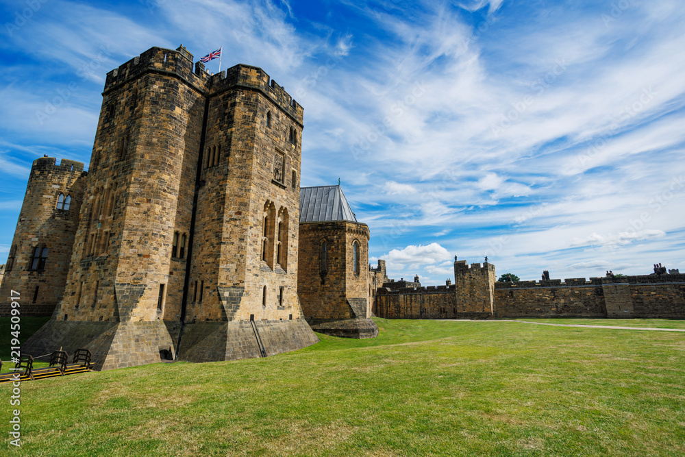 Obraz premium Historic English Alnwick castle with towers on grassy ground, UK