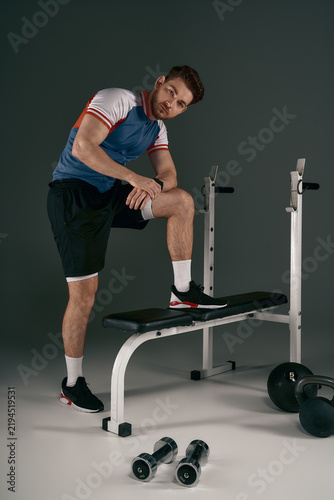 Obraz na plátně Sporty handsome young man posing confidently in a gym setting