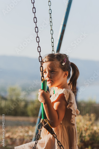 Happy Little Girl Enjoying a Summer Vacation on a Swing in Greece