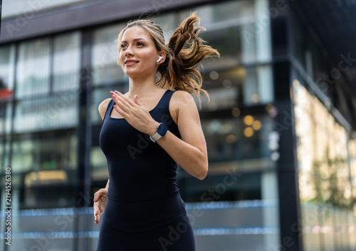 Caucasian woman running and workout in city for health, breathing and wellness with athlete training outdoor. Female person, cardio fitness and exercise with sports, self care and runner in urban town