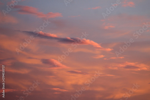 Vibrant sunset sky featuring glowing pink, orange, and blue clouds. Peaceful natural background ideal for travel, weather, nature, wallpaper, and atmospheric themes.